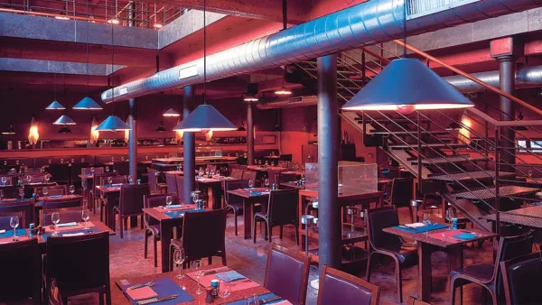 Lampy Aggregato od Artemide wiszące w restauracji w stylu industrialnym